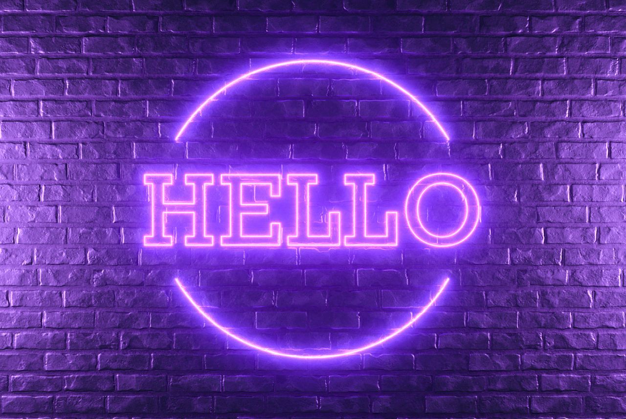 purple neon sign that says hello on a purple brick wall